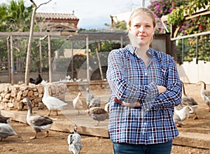 Smiling female farmer on poultry yard