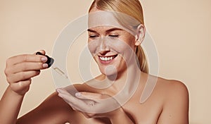 Smiling female with freckled skin testing serum consistency with fingers before applying