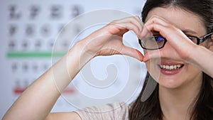 Smiling female in glasses making heart of hands, good service quality, care