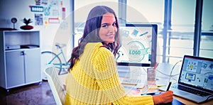 Smiling female graphic designer working in creative office