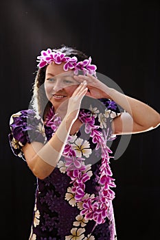 Smiling female Hawaiian girl dancing and singing with musical instruments like the ukulele