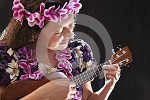 Smiling female Hawaiian girl dancing and singing with musical instruments like the ukulele