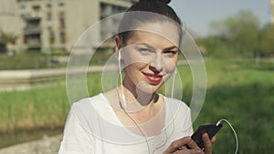 Smiling female in headphones with smartphone