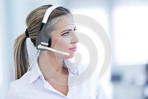 Smiling female helpline operator with headphones