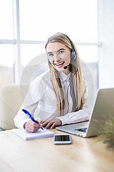 Smiling female helpline operator with headphones