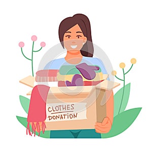 Smiling female holding box with clothes donation. Help and care for people in need