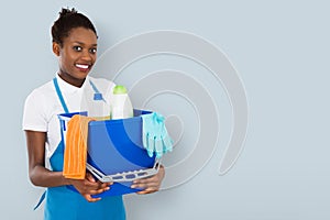 Smiling Female Janitor Holding Cleaning Equipment