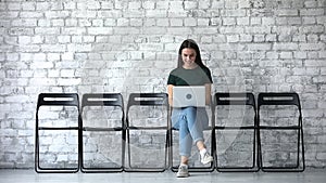 Smiling female job seeker using laptop wait for interview