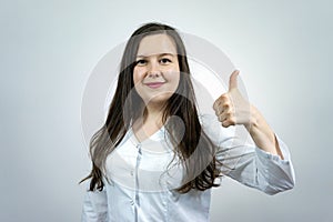 Smiling female medicine doctor showing ok sign with thumb up