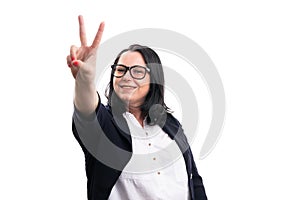 Smiling female model entrepreneur making peace or victory sign