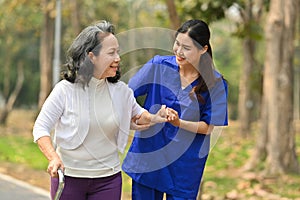 Smiling female nurse assisting senior woman in nursing home. Assistance and rehabilitation concept