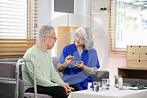 Smiling female nurse explaining medicine dosage to senior patient during home visit