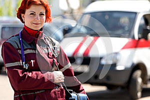 Smiling female paramedic with ambulance bag