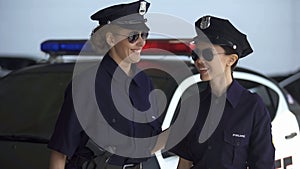 Smiling female patrol officers walking to police station, successful operation