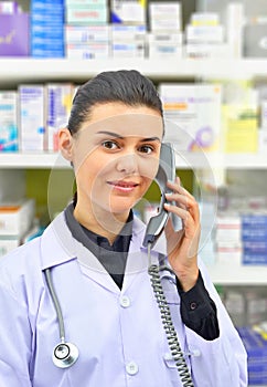 Smiling female Pharmacist Talking to Someone on Phone on pharmacy background