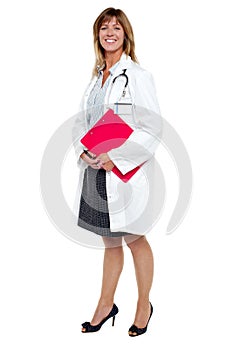 Smiling female physician holding clipboard