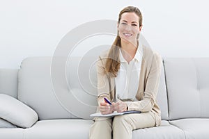 Smiling female psychologist sitting on sofa