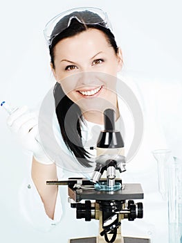 Smiling female researcher working on micr