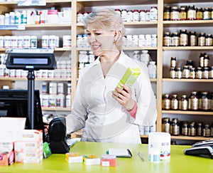 Smiling female seller checking assortment in store