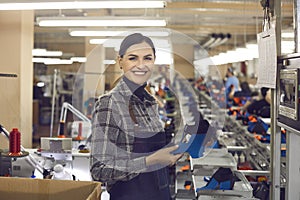 Smiling female shoe designer smiling to camera holding part of new footwear