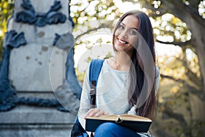 Smiling female student holding book