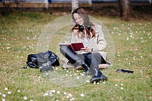 smiling female student learning remotely outdoors in park