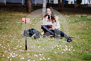 smiling female student learning remotely outdoors in park