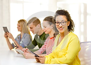 Smiling female students with tablet pc at school