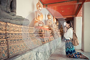 Smiling female tourist kneel down in Bangkok
