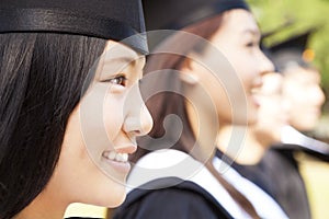 smiling female university graduate with classmates