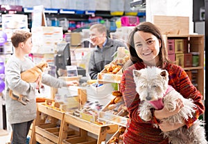 Smiling female visitor with dog in petshop