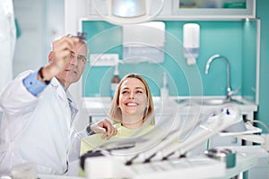 Smiling female woman with dentist looking at dental snapshot