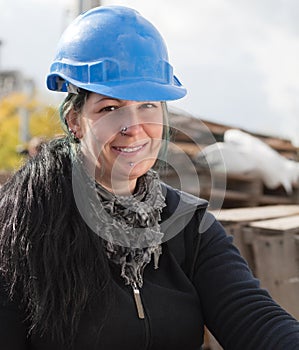 Smiling female worker in blue hard hat