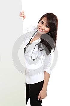 Smiling female young doctor holding blank white board