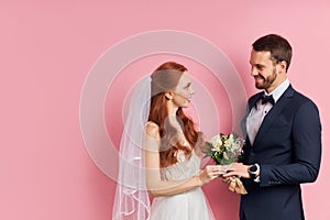 Smiling fiance and bride isolated over pink background