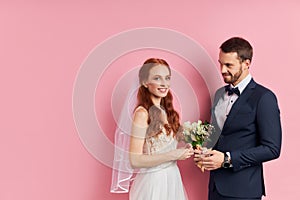 Smiling fiance and bride isolated over pink background