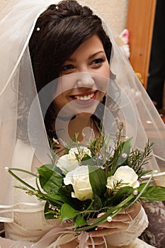 Smiling fiancee with flowers in the hands