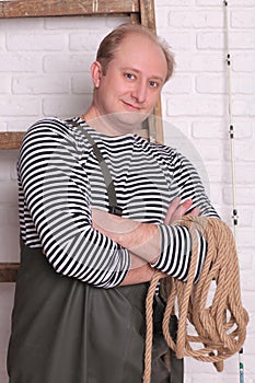 Smiling fisherman in waders with rope