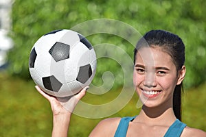 Smiling Fit Asian Female Soccer Player With Soccer Ball