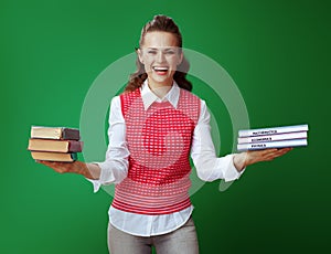 Smiling fit student showing old and new textbooks