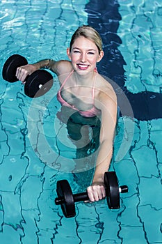 Smiling fit woman doing aqua aerobics