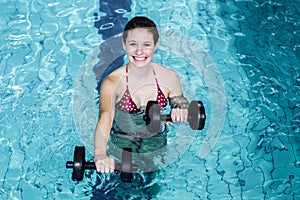 Smiling fit woman doing aqua aerobics