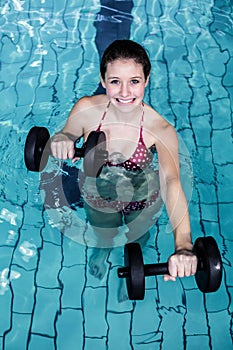 Smiling fit woman doing aqua aerobics