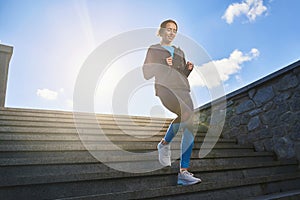 Smiling fit woman going jogging in city