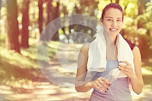 Smiling fit woman with white towel resting after sport exercises