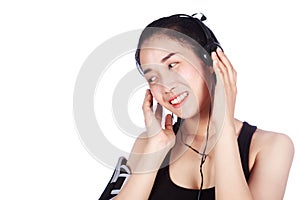 Smiling fitness woman listening to music with earphones isolated