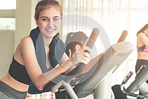 Smiling Fitness woman is running on treadmill with friends