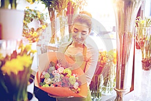 Smiling florist woman with bunch at flower shop