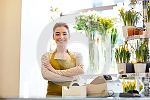 Smiling florist woman at flower shop cashbox