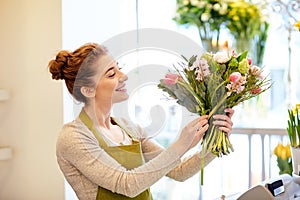 Smiling florist woman making bunch at flower shop